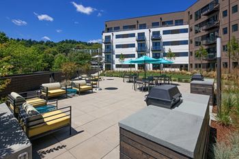 A patio area with a table and chairs and a grill.